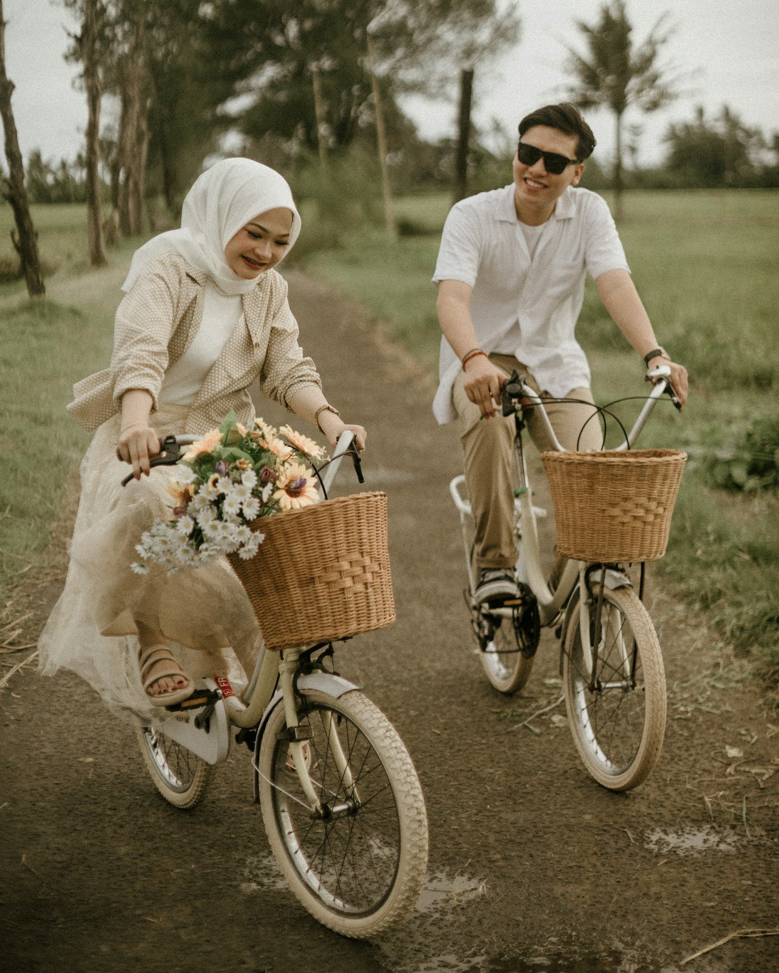 Pareja joven en bicicleta con gafas de sol en un paseo al aire libre